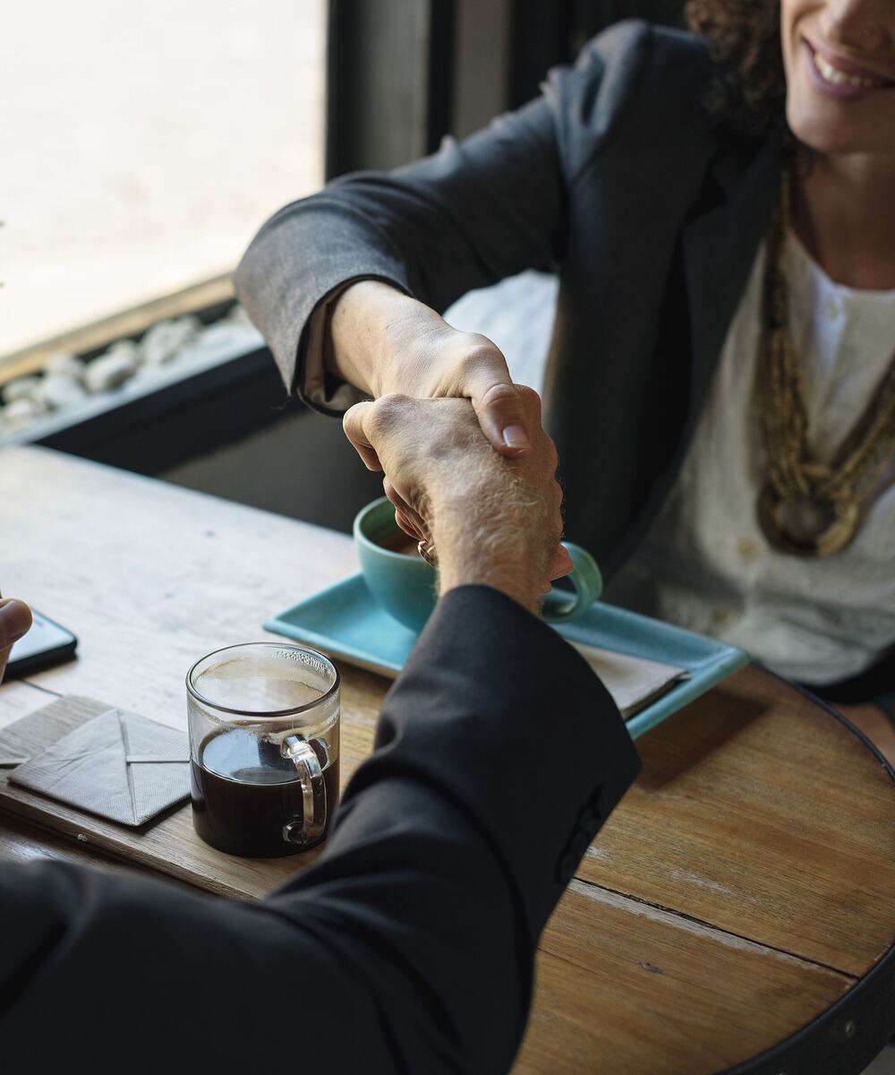 Apretón de manos entre dos profesionales durante una reunión de negocios
