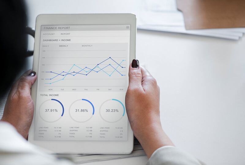 Persona revisando un reporte financiero con gráficas en una tableta